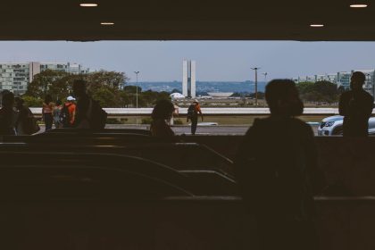 Silhuetas de pessoas em uma passagem subterrânea diante do Congresso Nacional, em Brasília.