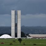 Vista do Congresso Nacional, em Brasília, com suas cúpulas e torres diante do céu aberto.