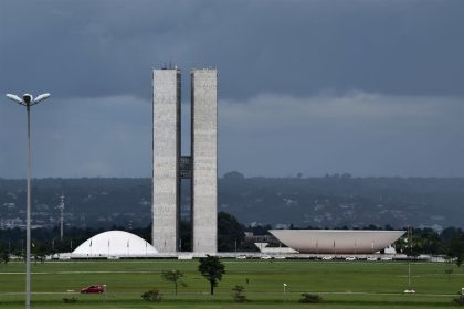 Vista do Congresso Nacional, em Brasília, com suas cúpulas e torres diante do céu aberto.