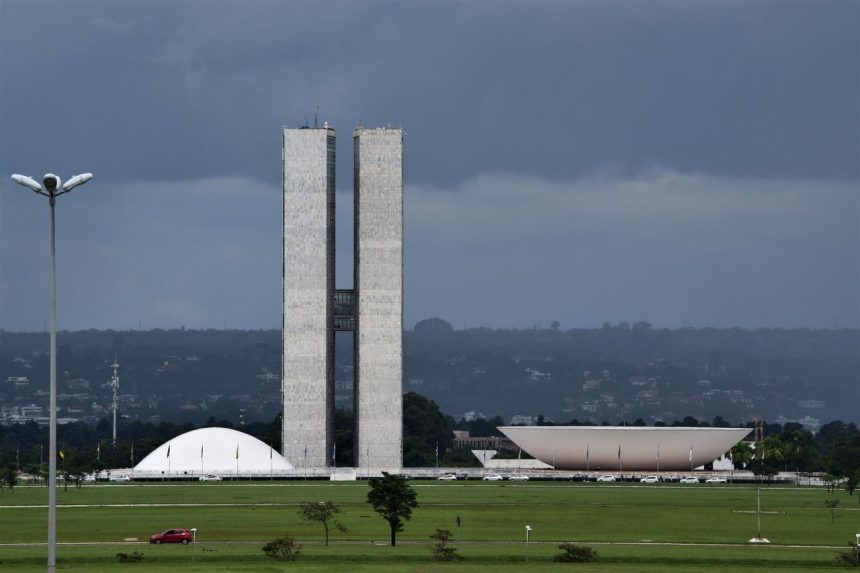Vista do Congresso Nacional, em Brasília, com suas cúpulas e torres diante do céu aberto.