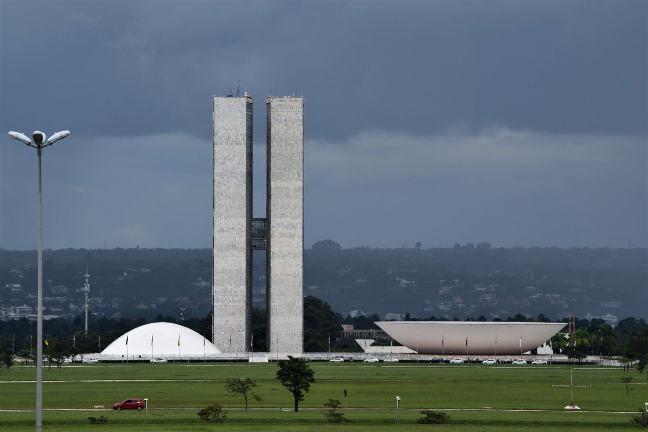 Vista do Congresso Nacional, em Brasília, com suas cúpulas e torres diante do céu aberto.