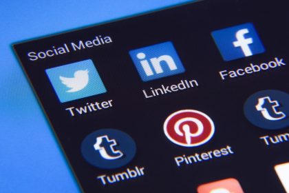 Smartphone cercado por ícones de redes sociais e elementos de comunicação digital.